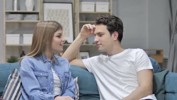 Happy Girl Talking with Boyfriend Relaxing on Couch Discussing