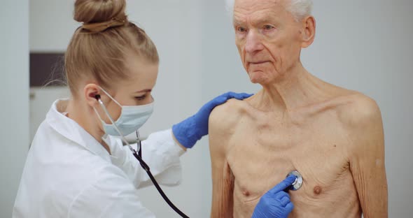 Female Doctor Examine Elderly Man with Stethoscope