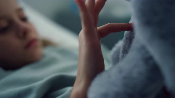 Closeup Sad Little Patient Touching Soft Toy in Ward