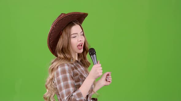 Girl Sings Into a Retro Country Music Microphone. Green Screen. Side View