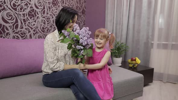 Little Daughter Child Congratulates Mother with Bouquet of Flowers. Slow Motion