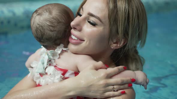 Mother Hugs Her Little Baby in the Pool