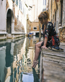 Redhead girl with floral dress sitting near venice canal bare feet - PhotoDune Item for Sale