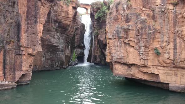 Aerial shot of a waterfall surrounded by cliffs in South Africa.