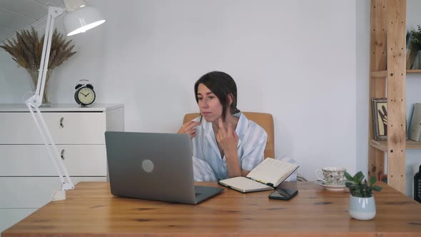 A Young Woman Admires Herself in the Reflection of the Laptop Display