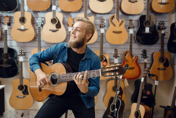 Assortment in musical instruments shop, male musician buying equipment