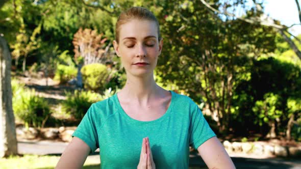 Women performing yoga in park