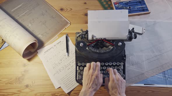 Vintage architecture desk with typewriter, blueprints and rulers