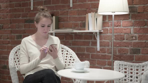 Woman Having Coffee and Celebrating Success on Smartphone