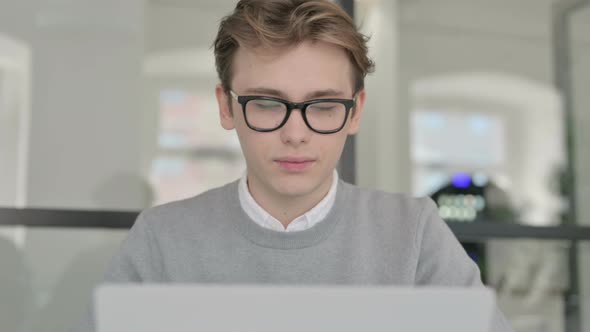 Close Up of Young Man with Laptop Showing Thumbs Up Sign