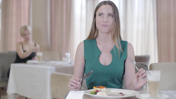 Proud Caucasian Woman Eating Sweet Cherry with Ice Cream in Restaurant. Portrait of Confident