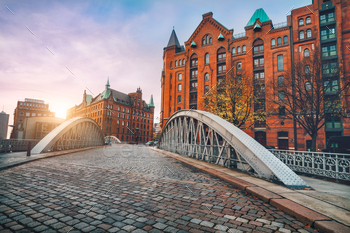 n historical Speicherstadt of Hamburg, Germany, Europe. Scenic view of red brick building lit by golden sunset light.