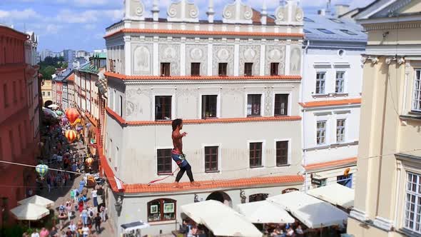 Man Balances on Tight Rope a View of the City From Height