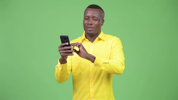 Young African Businessman Using Phone and Getting Bad News