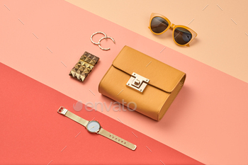 ion beauty accessories. Trendy Clutch, Brushes, lipstick. Coloful fashionable orange coral art Flat lay. Creative geometry concept