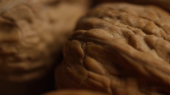 Cinematic, rotating shot of walnuts in their shells on a white surface - WALNUTS 