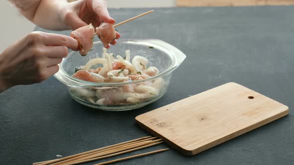 Woman's Hands Cooking Marinated Shashlik or Shish Kebab, Chicken Meat on Wooden Skewer