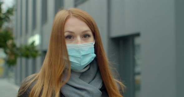 Young Redhead Woman Wearing a Medical Protective Mask Against Infectious Diseases, Walking