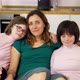 Portrait of Two Girls with Down Syndrome in Sitting on a Couch Together Embracing with Their Mom - VideoHive Item for Sale