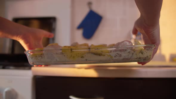 Woman Puts a Tray with Food in the Stove at Home in the Kitchen Put on Bake