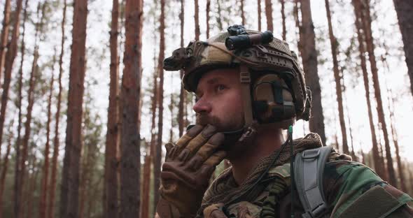 Portrait of a Bearded Middleaged Soldier in a Woodland Military Uniform and a Helmet with Headphones