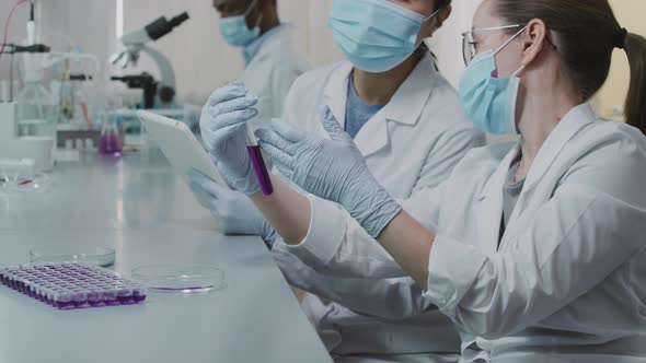 Female Scientists Inspecting Solution in Test Tube