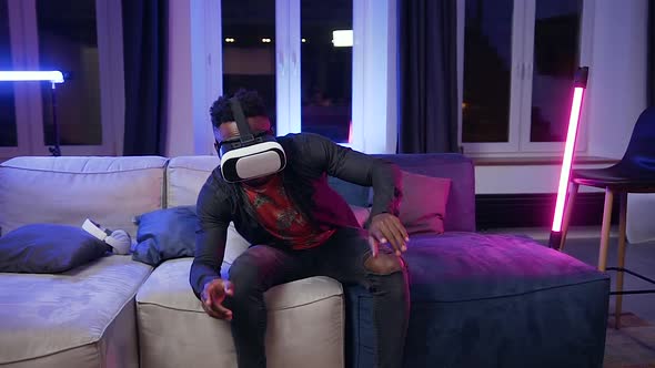 Man in Virtual Reality Headset Sitting on the Couch in the Contemporary Room