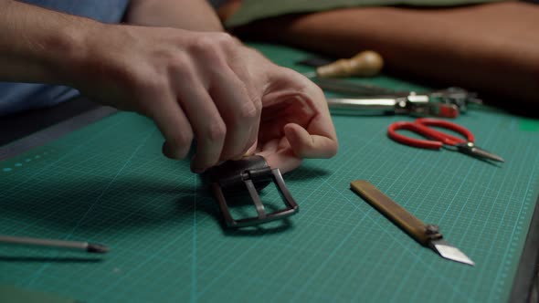 Artisan Getting Buckle and Leather Details of Belt Together Indoors