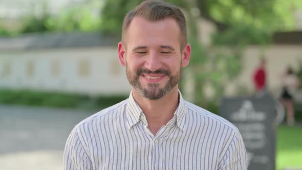 Outdoor Portrait of Middle Aged Man Shaking Head As Yes Sign