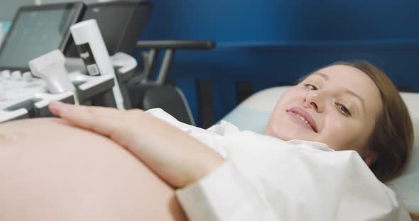 Happy Pregnant Woman Lying Down Getting Ultrasound Investigation