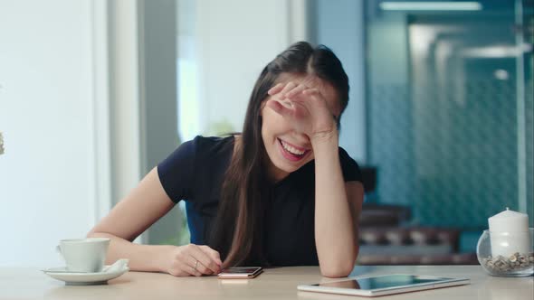 Young Woman in a Cafe Can't Stop Laughing To the Camera