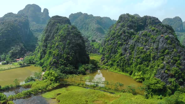 Aerial: North Vietnam karst landscape at sunset, drone view of Ninh Binh region, tourist destination