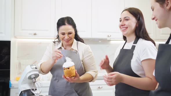 a Happy Women Decorate Icing Dried Berries and Flowers Easter Cakes