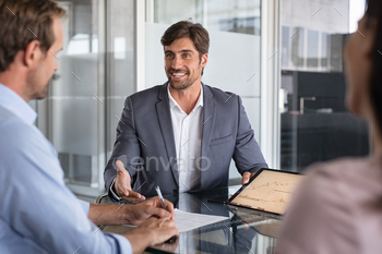 couple. Mid couple meeting financial advisor for investment. Business people discussing the charts and graphs showing the results of their successful teamwork.