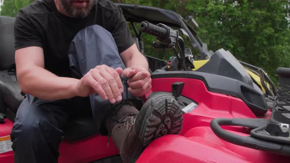 Quad Bike Rider Tying Laces on Boots