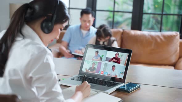 Asian business woman talking to colleagues team about plan in video conference with family at home.