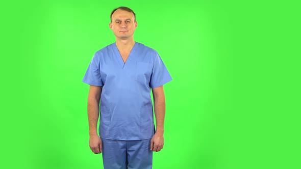 Medical Man Standing, Spreads Out in a Smile and Looks at the Camera. Green Screen