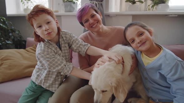 Portrait of Joyous Family with Lovely Dog on Sofa