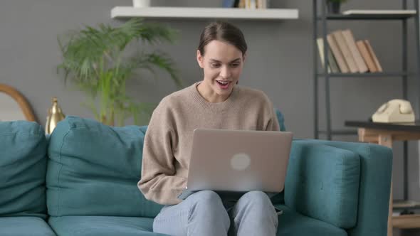 Woman with Laptop Thinking on Sofa