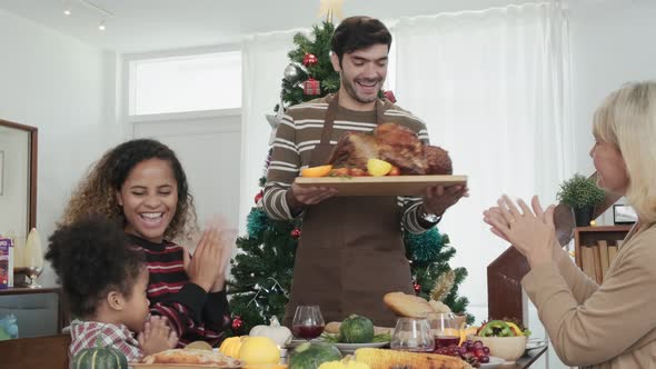 family having holiday dinner and cutting turkey Thanksgiving Celebration