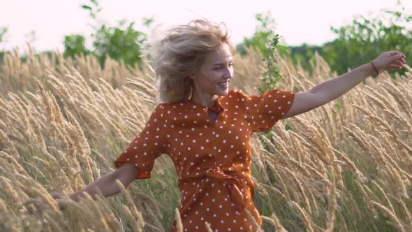 Attractive Fun Hippie Blonde Woman in the Field at Sunset Having Good Time Outdoors