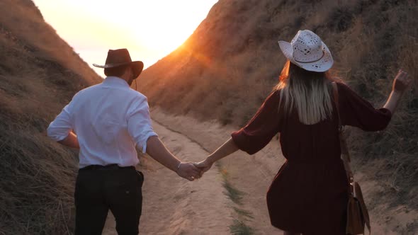 Couple in love. Traveler-bloggers running down the mountain. 