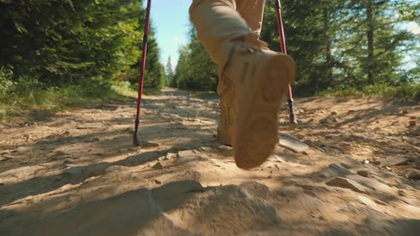 A Man with Trekking Poles Climbs the Mountains, Close-up