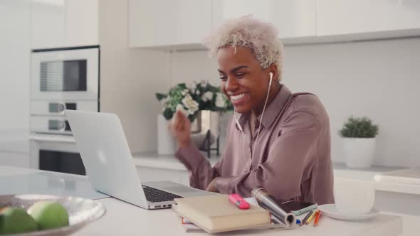 Young African American Woman Student Celebrating Victory By Looking on Laptop
