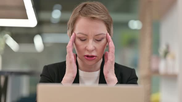 Close Up of Old Businesswoman with Laptop Having Headache 