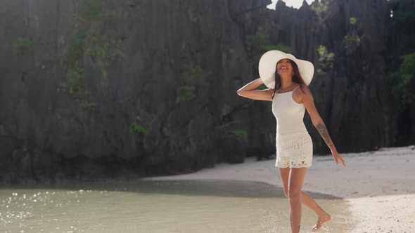 Laughing Young Woman In Sun Hat Turning To Run Through Tide