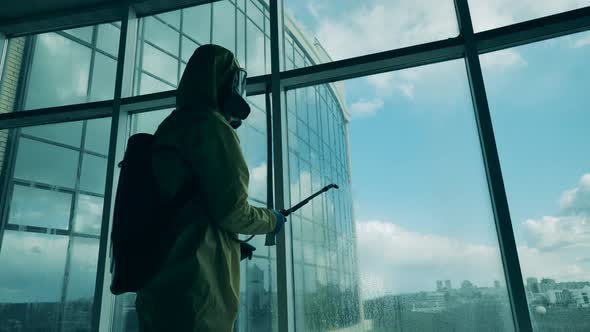 Sanitation Worker Sprays Windows in a Building