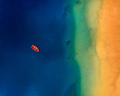 Aerial view of a lonely red boat anchored off the coast of Las Teresitas beach - PhotoDune Item for Sale