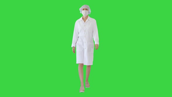 Walking Female Doctor Wearing Surgical Mask on a Green Screen, Chroma Key.