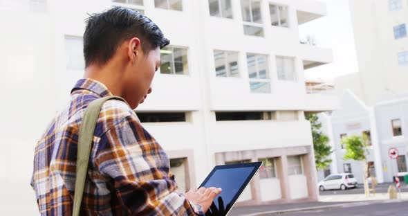 A man walking and using a tablet computer